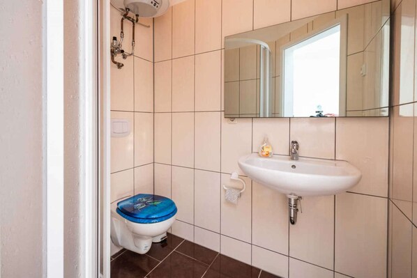 Un baño con inodoro, lavabo y espejo.