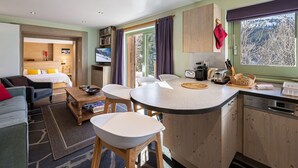 Ein kompaktes Hotelzimmer mit Küchenzeile, Essbereich, Wohnbereich und Schlafzimmer.