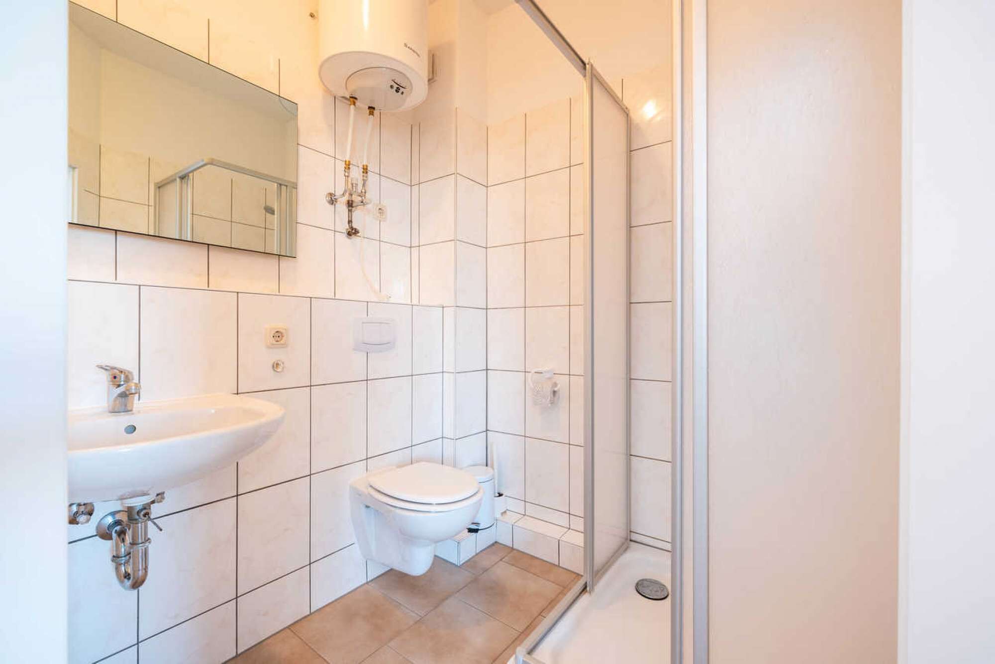 Ein modernes Badezimmer mit Toilette, Waschbecken und Dusche.