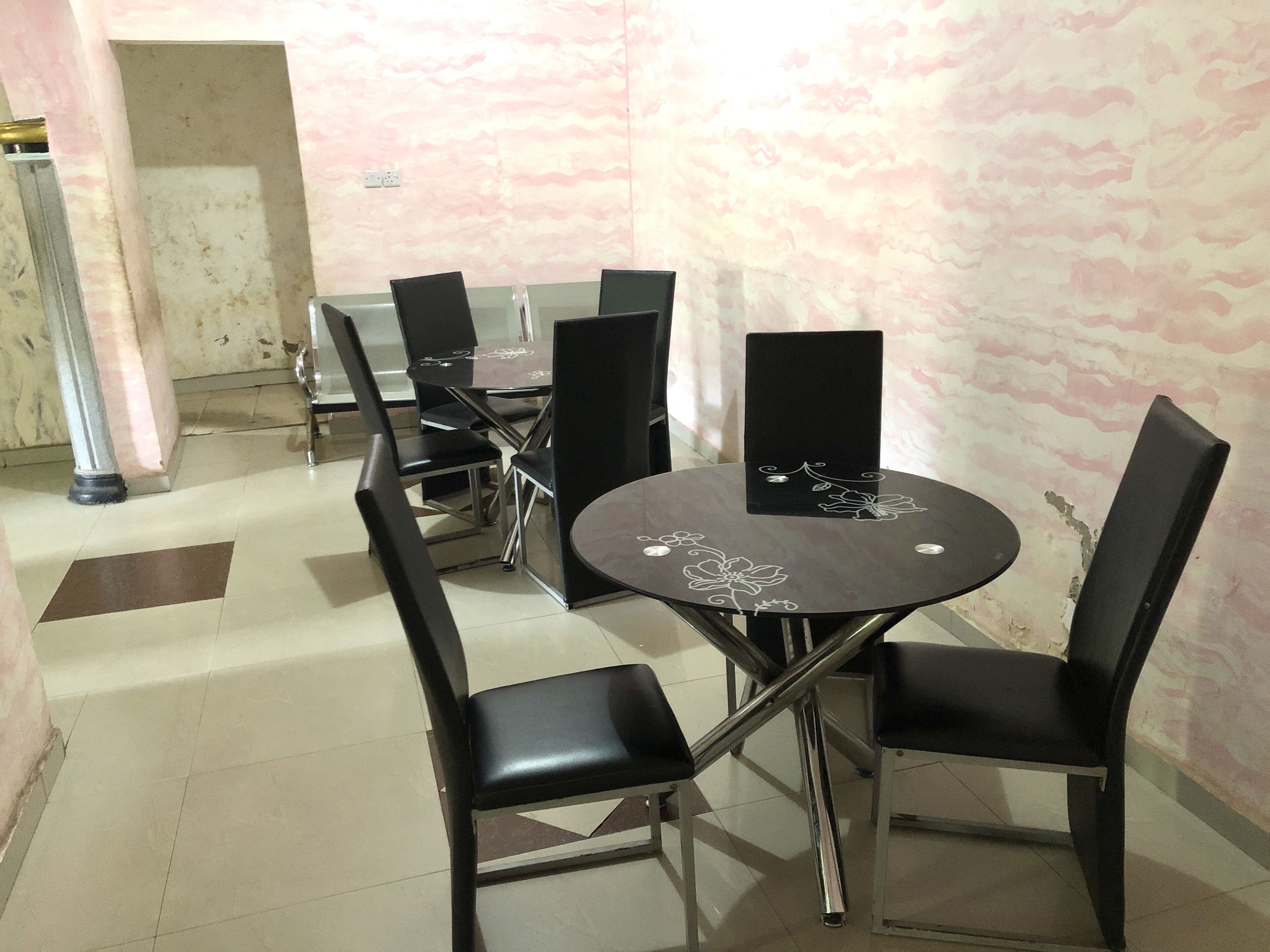 A conference room with a round table and black chairs.
