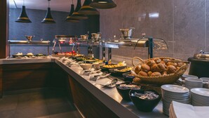 A buffet setup with various food items and utensils.