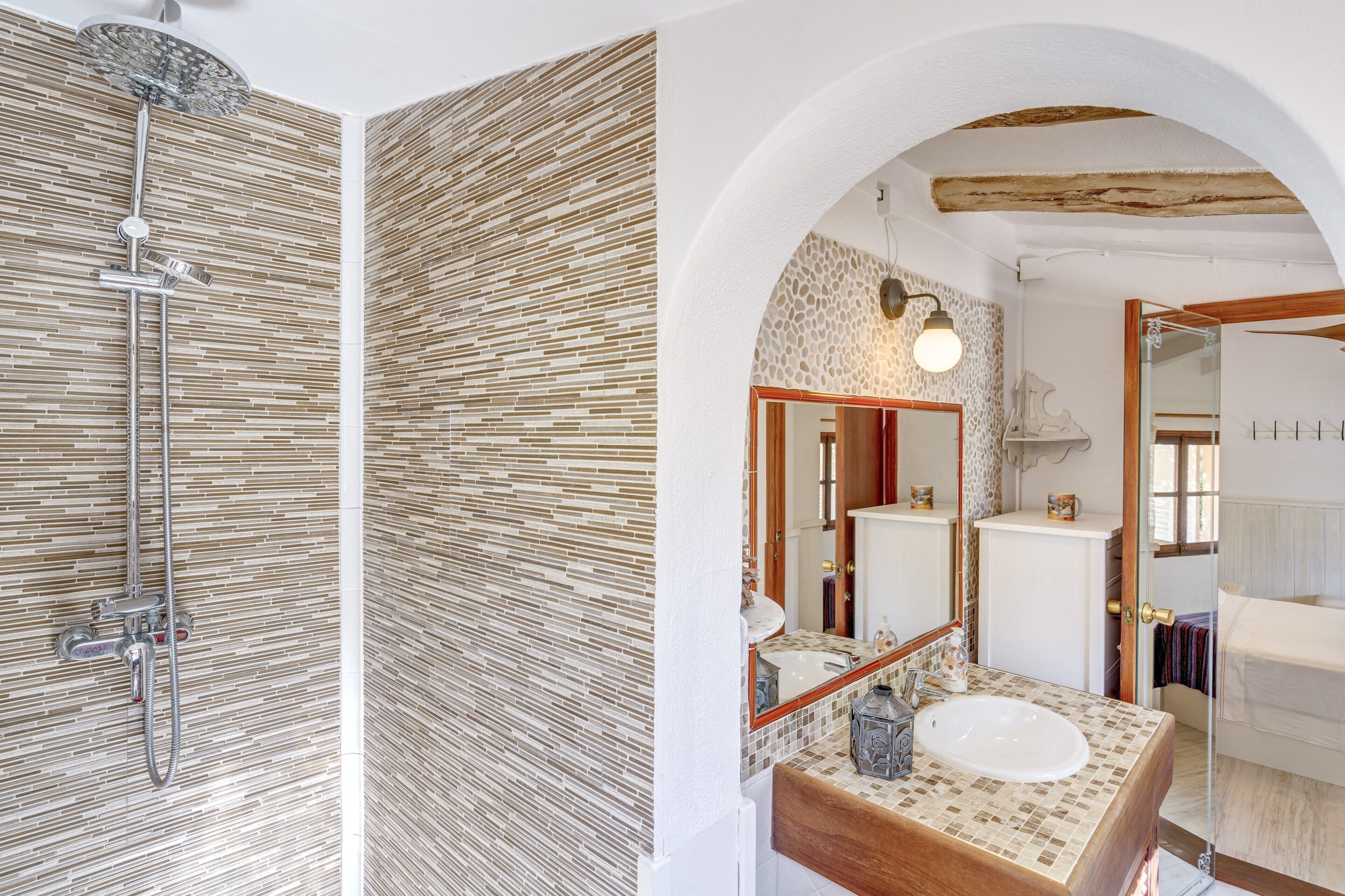 A bathroom with a shower, a sink, and a mirror.