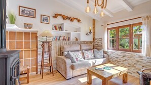 A cozy living room with a fireplace, a sofa, a coffee table, and a bookshelf. - Finca “Ses Begudes” with Garden, Terrace, Pool, Air Conditioning & Wi-Fi (Fornalutx)
