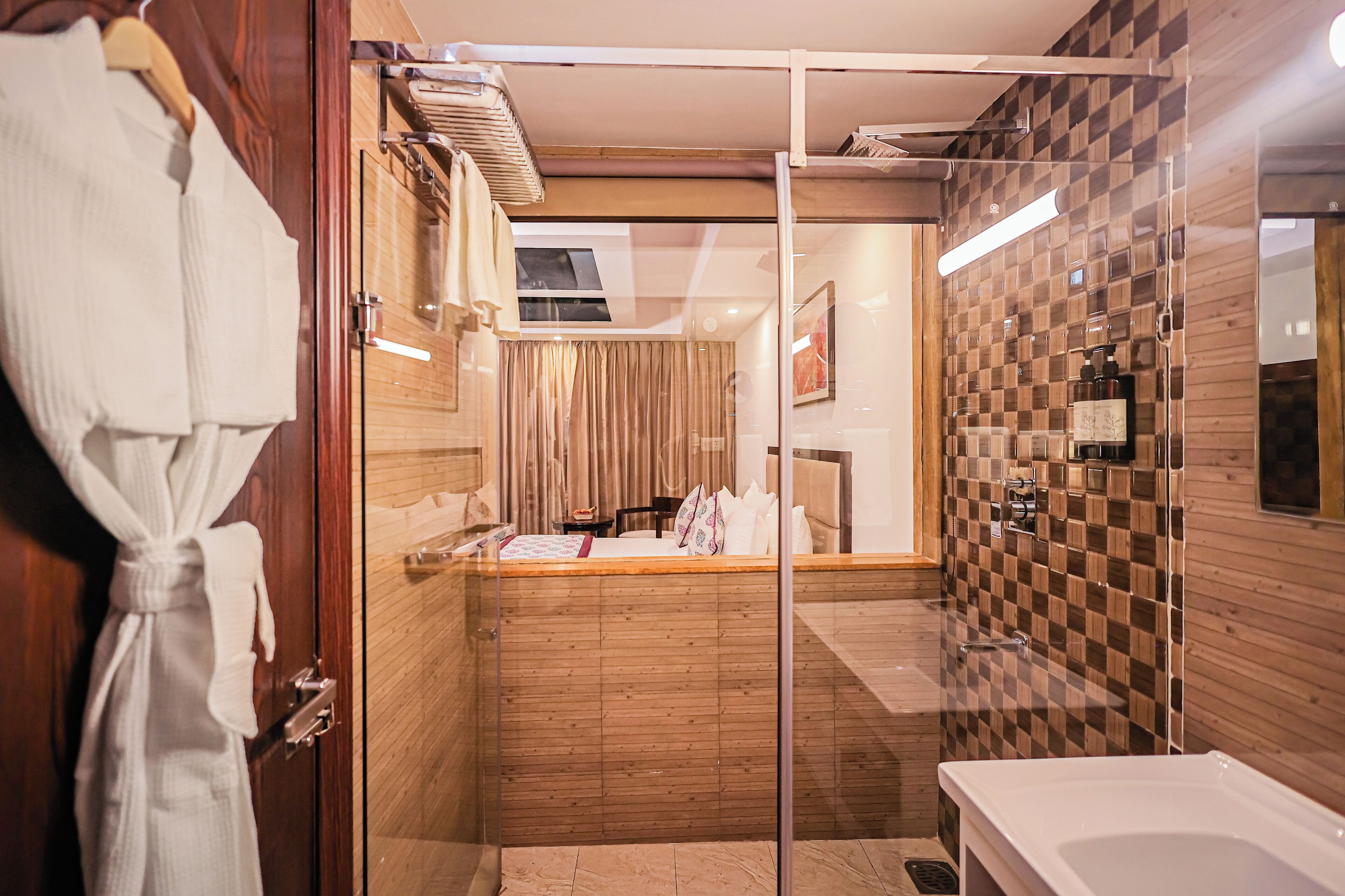 Een moderne badkamer met een douchecabine van glas, een houten wastafelmeubel en een apart badgedeelte.