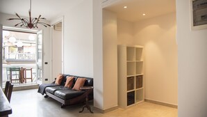 Ein modernes Wohnzimmer mit einer Ledersofa, einem kleinen Tisch und einer eingebauten Regaleinheit.