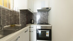 A compact kitchen with a gas stove, oven, and stainless steel appliances. - Studio Flat in a Quiet Place (Milan)