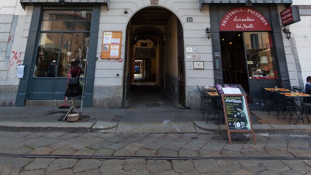 A multi-story building with a ground-floor shop. - Typical Apartment on River Naviglio / Darsena (Milan)