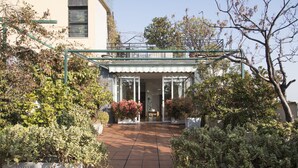 A courtyard with a covered entrance, potted plants, and a tiled floor. - The Traveller's Terrace (Milan)