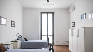 A room with two beds, a wardrobe, a desk, and a window. - Bright & Cozy Flat near Navigli, Iulm, Tortona (Milan)