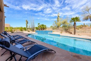 A pool with lounge chairs, surrounded by desert vegetation and a clear sky. - Troon North Beautiful Home on the Golf Course! (Scottsdale)