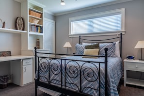 A bedroom with a bed, bedside tables, a desk, and shelving. - Vineyard Views + Fire Pit BBQ | Paso Wine Country | Estrella Vineyard (San Miguel)