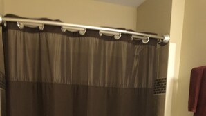Een badkamer met een bad, toilet en douchegordijn.