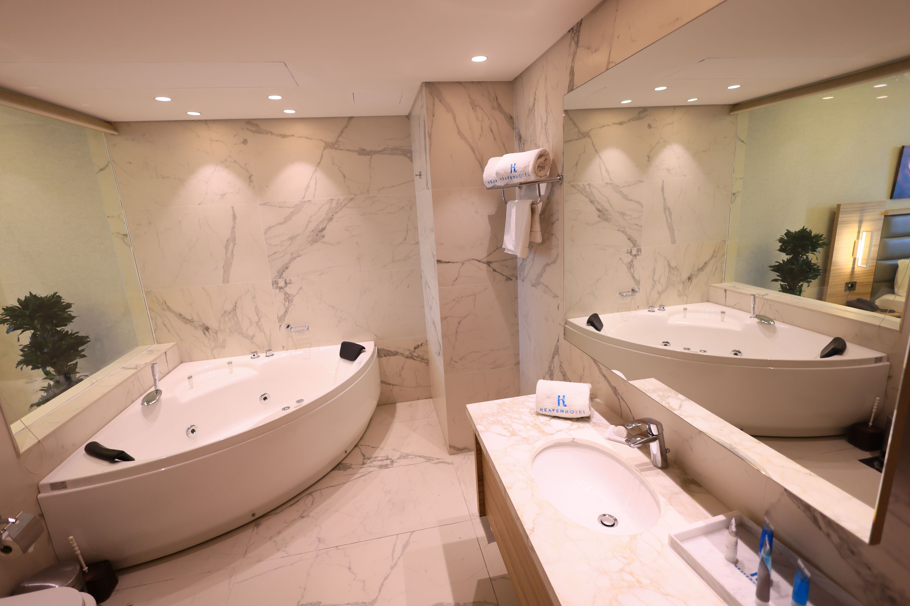 A modern bathroom with a large freestanding bathtub, a separate sink, and a mirror above the sink.