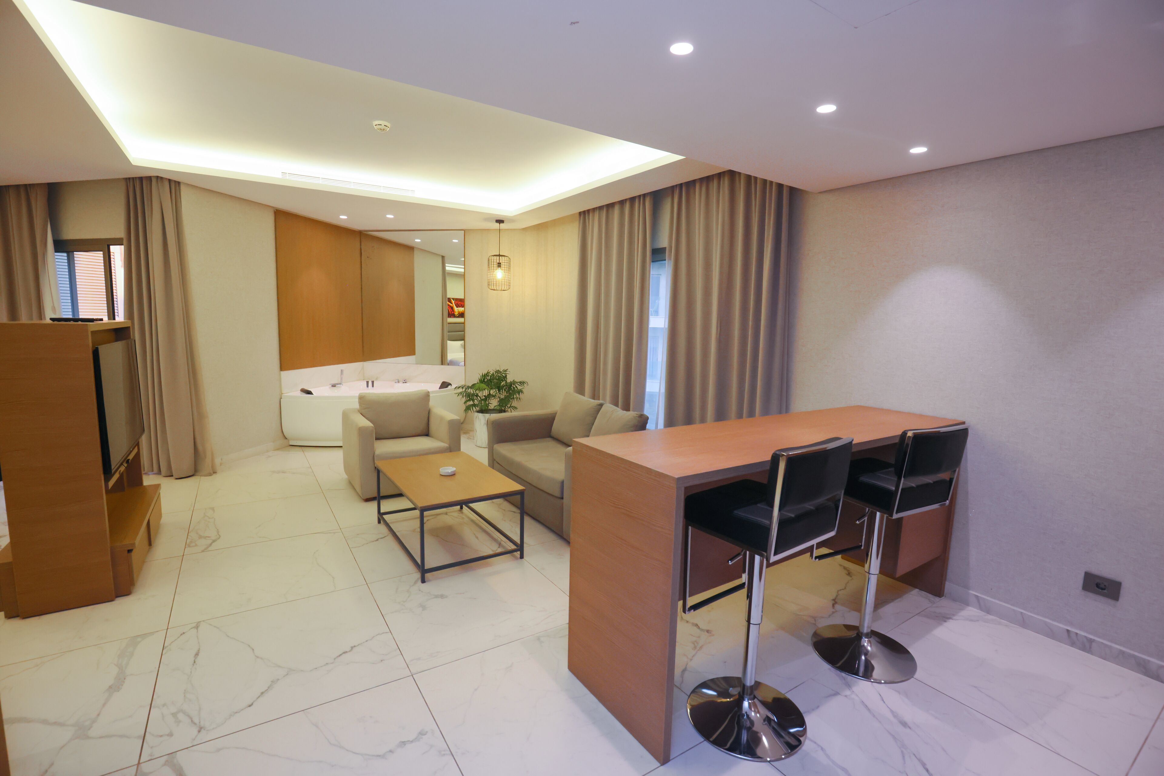 A modern living room with a wooden coffee table, a sofa, and a dining area with a table and chairs.