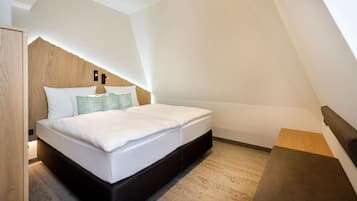 Um quarto moderno com cama beliche, cabeceira de madeira e um pequeno banco de madeira.
