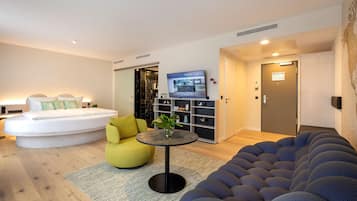Ein modernes Wohnzimmer mit einer Couch, einem runden Tisch und einem Bett mit einem außergewöhnlichen Design.