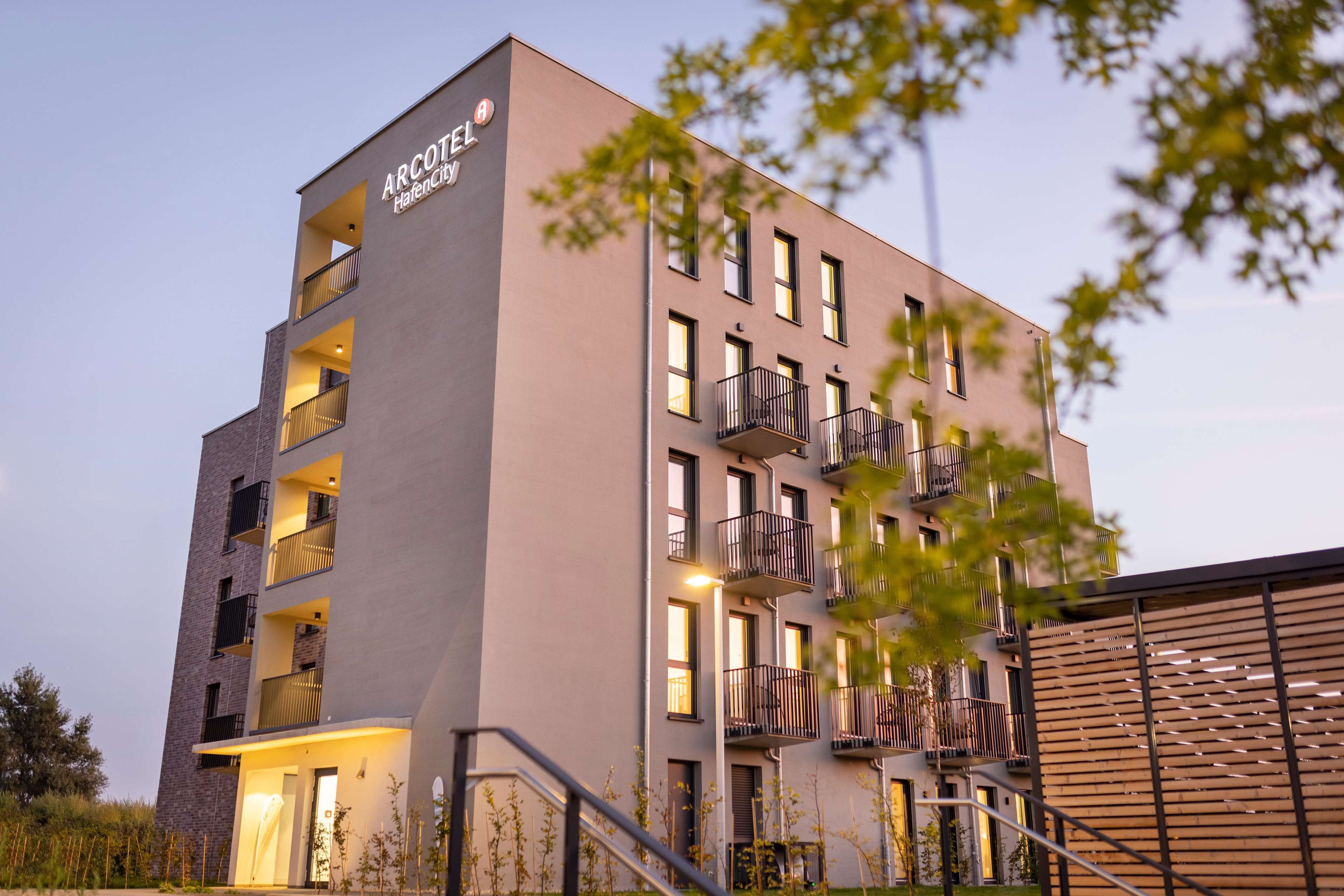 A multi-story hotel with balconies and a sign reading "ARCOTEL".