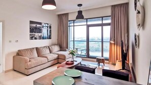 Ein modernes Wohnzimmer mit einer Couch, einem Esstisch und großen Fenstern mit Blick auf die Stadt.