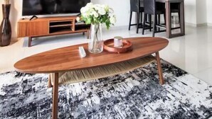 Ein modernes Wohnzimmer mit Flachbildfernseher, einer Holzunterhaltungsecke und einem Couchtisch.