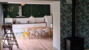Una cocina moderna con armarios blancos, una mesa de comedor de madera y una estufa negra.