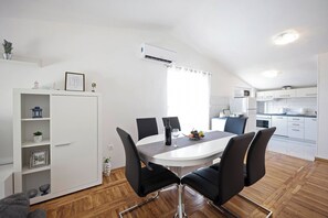 Une cuisine moderne avec des meubles blancs, un four à micro-ondes et une cuisinière.