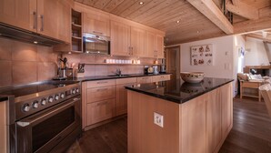 Una cocina moderna con armarios de madera, estufa de acero inoxidable y una isla central.