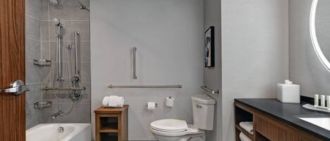 A modern bathroom with a bathtub, shower, toilet, and vanity.