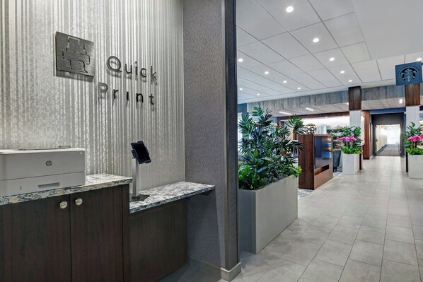 A reception area with a 'Quick Print' sign, a printer, and a reception desk. - Courtyard by Marriott Hamilton (Robbinsville)