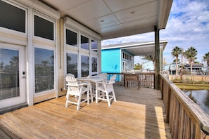 Enjoy a peaceful moment on the deck overlooking the water, surrounded by lush surroundings and a comfortable seating area.
