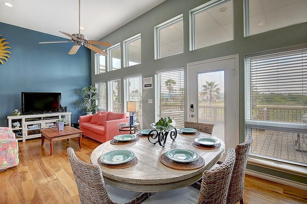 Relax in this spacious living room with a large window, TV, and comfortable seating area.