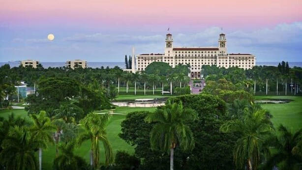 A large, historic building with two towers, surrounded by lush greenery and a golf course. - 1/1 steps from downtown w/bikes. clean & comfortable (West Palm Beach)