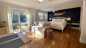 A bedroom with a bed, a sofa, a dining table, and a view of the outdoors. - Studio steps from Intracoastal & downtown WPB with bikes (West Palm Beach)