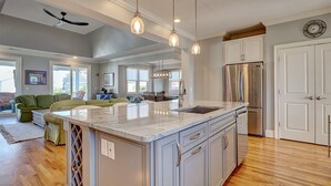 A spacious kitchen with a large island, stainless steel appliances, and pendant lighting. - Relaxing home, just a short walk to the beach and the Intracoastal Waterway (Wrightsville Beach)