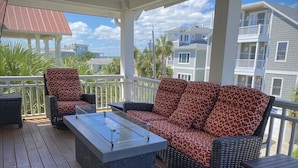 A covered outdoor seating area with wicker furniture and a foosball table. - Relaxing home, just a short walk to the beach and the Intracoastal Waterway (Wrightsville Beach)