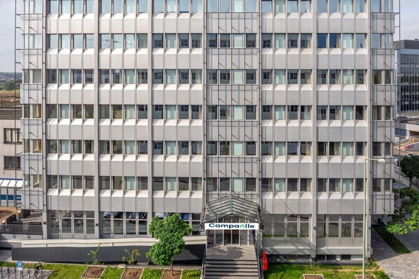 A modern building with a grid of windows and a central entrance.