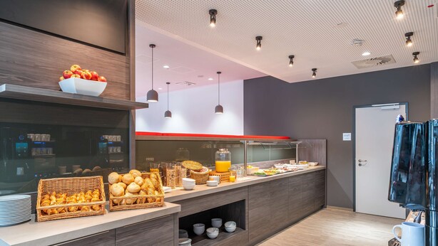 Un desayuno buffet moderno con una variedad de pasteles, frutas y bebidas.