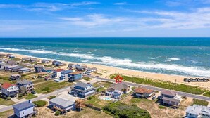 A coastal residential area with houses, a road, and the ocean. - Pet Friendly, Ocean Views, Pool & Hot Tub! (Kitty Hawk)