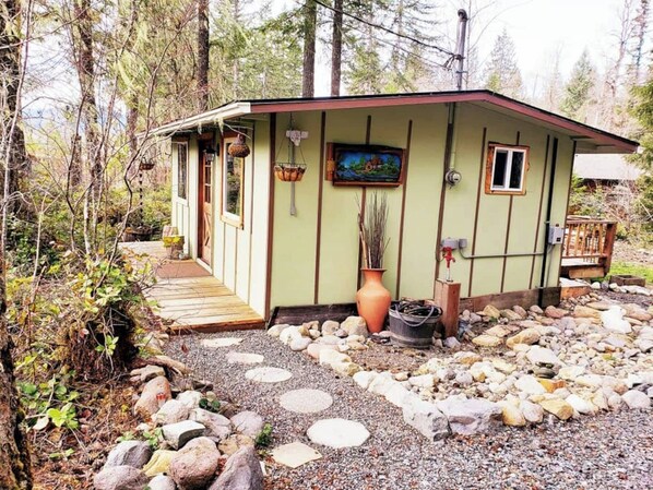 A small cabin with a wooden deck, surrounded by rocks and trees. - *Little Green Cabin on Big Creek * 5 mi to Mt. Rainier entrance! (Ashford)