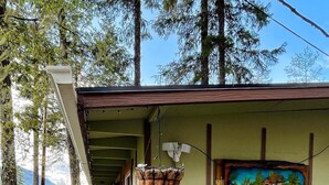 Una cabaña rústica con terraza de madera, un cuadro de una casa en la pared y un letrero que dice "HOMEMADE".