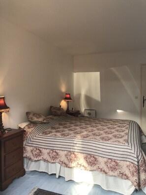 A bedroom with a bed, two bedside lamps, a nightstand, a dresser, and a window casting a shadow. - Provençal villa with pool and a lovely view of the hills (Bagnols-en-Forêt)