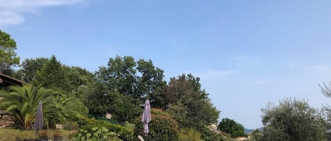 Een buitenzwembad, ligstoelen bij het zwembad