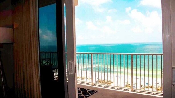 A balcony with a view of the ocean and beach.