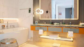 A modern bathroom with a large mirror, a bathtub, and a vanity with a countertop.