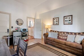 Un salon comprenant un canapé, une table basse et un coin repas avec des chaises.