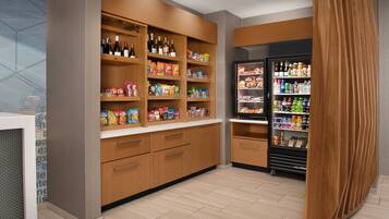 A hotel pantry with shelves stocked with snacks, beverages, and bottled water.