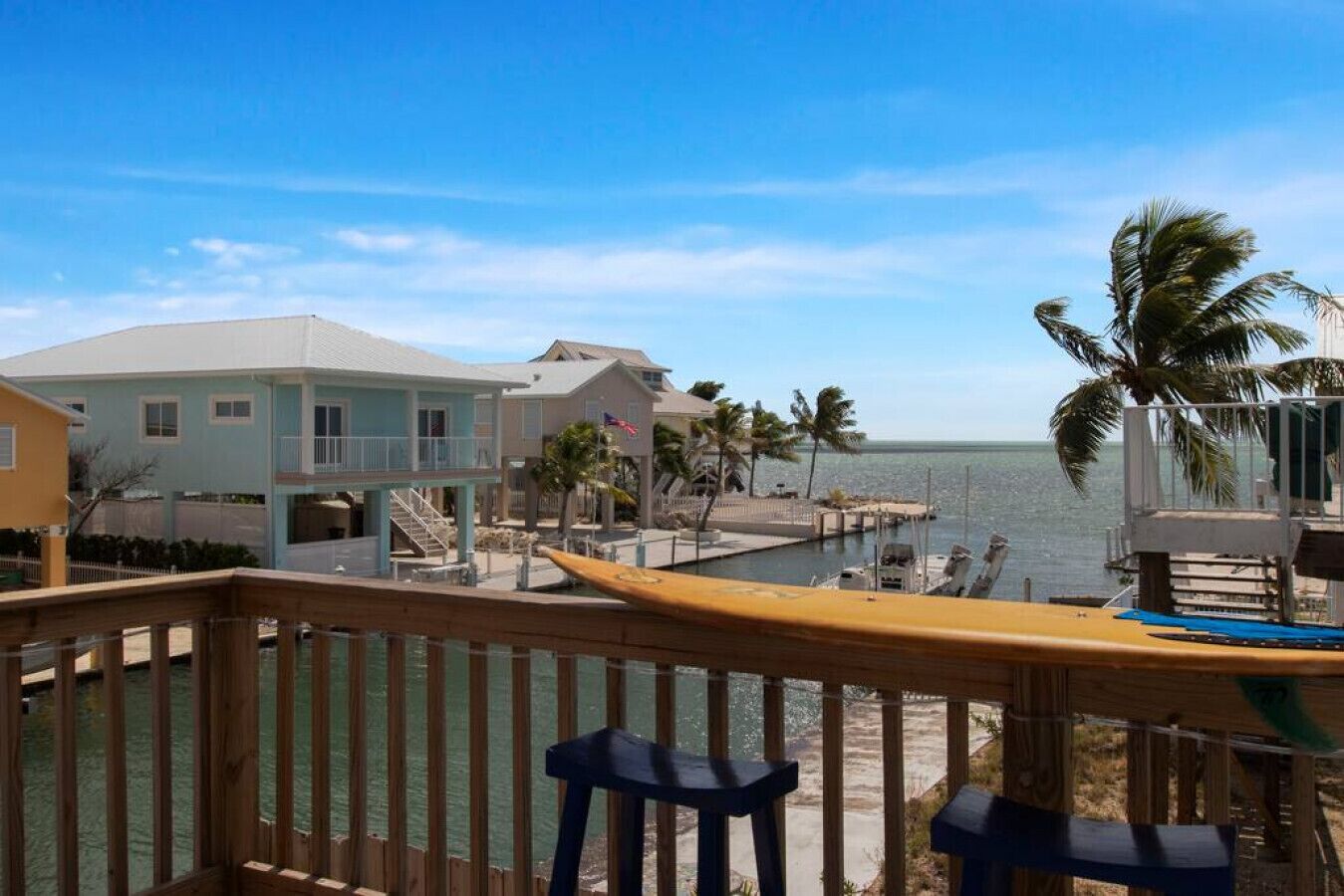 A wooden deck with a view of a marina and ocean.