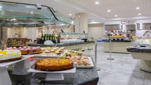 Un área de bufé con diversos postres y bebidas.