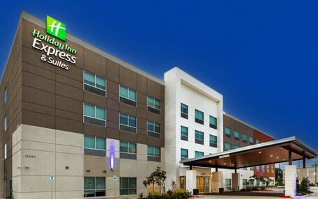 A Holiday Inn Express building with a modern design, featuring a prominent sign and a covered entrance area.