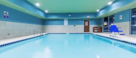 Piscina interna com sinalização clara, cadeira de salva-vidas e placa com as regras da piscina.