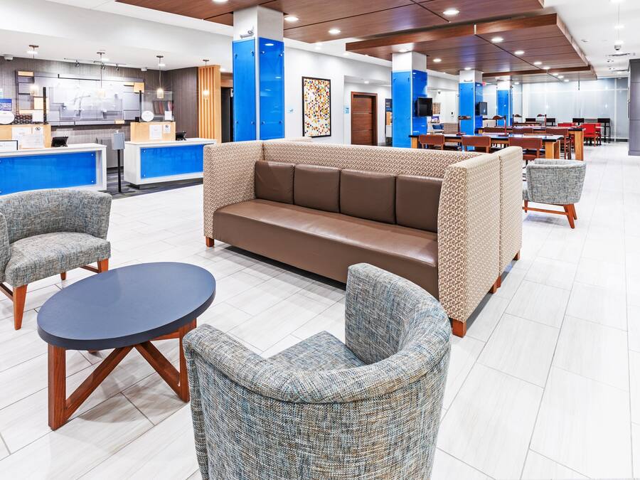 Eine moderne Lobby mit Empfangsbereich, Sitzgelegenheiten und Essbereich.